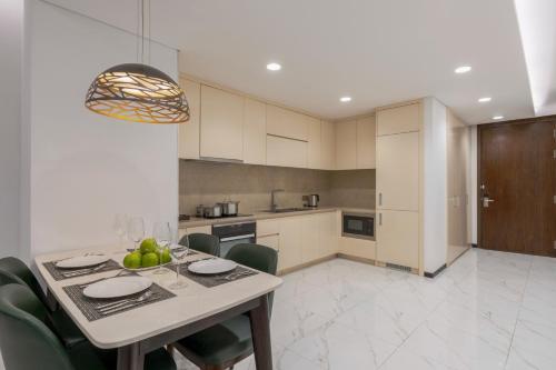a kitchen and dining room with a table and chairs at The Five Residences Hanoi in Hanoi