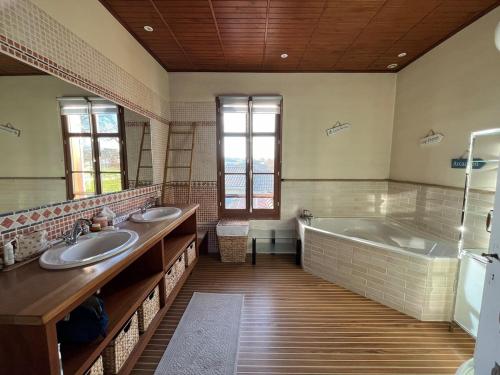 La grande salle de bains est pourvue de 2 lavabos et d'une baignoire. dans l'établissement Villa Joli Bois, à Foussolles