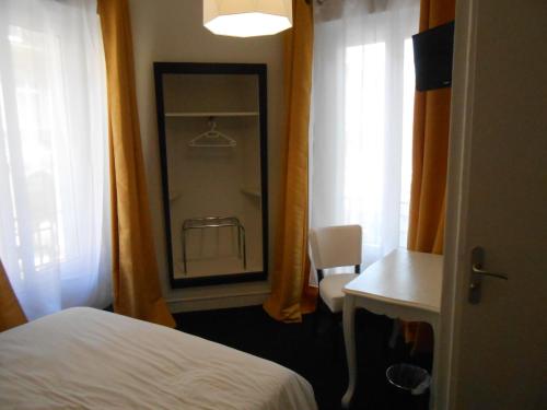 a bedroom with a bed and a window with a chair at Régina Boutique Hotel in Avignon