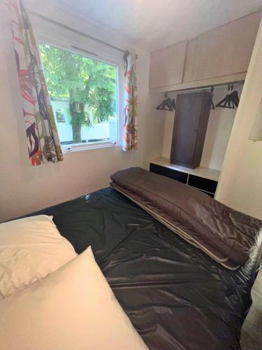 a bedroom with a bed and a window at F011- Bungalow ensoleillé pour 4 proche EuropaPark in Boofzheim