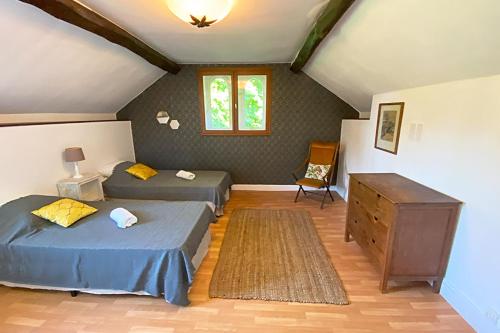 - une chambre avec 2 lits et une commode dans l'établissement La maison du gardien, à Sillé-le-Philippe