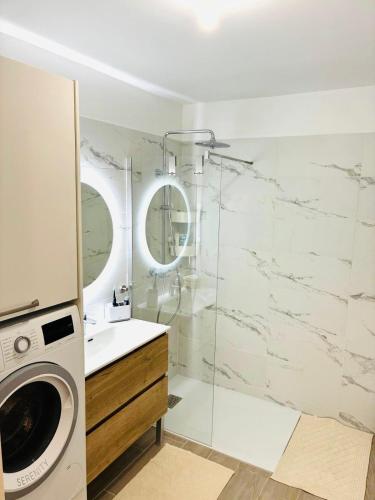 une salle de bain avec un lavabo et une machine à laver dans l'établissement Le Bougainvillier, à Cavalaire-sur-Mer