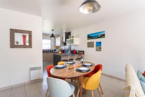 une cuisine et une salle à manger avec une table et des chaises en bois dans l'établissement La Pointe aux Chèvres - 10min à Pied de la Plage, à Fréhel