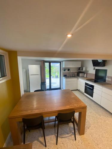 une cuisine avec une table en bois et deux chaises dans l'établissement T3 rez de jardin, à Pornichet
