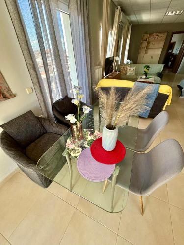 a living room with a glass table and chairs at Alpha Apartment View in Serres