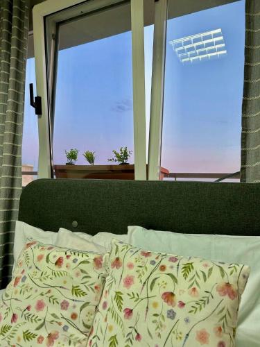 a bed with a pillow in front of a window at Alpha Apartment View in Serres