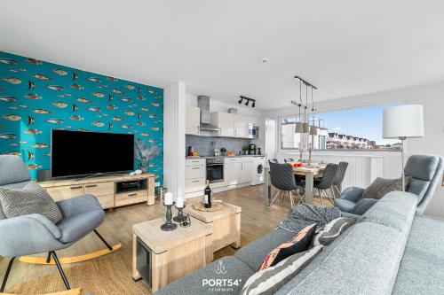 a living room with a couch and a tv at Ferienhaus Am Pier Olpenitz in Olpenitz