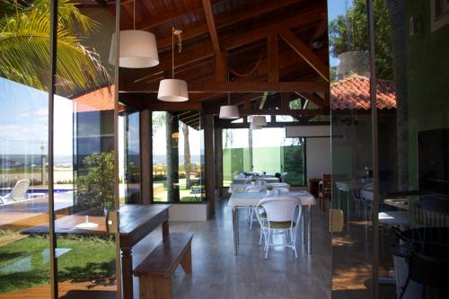 a restaurant with tables and chairs and glass walls at Posada Sueños De Verano in Florianópolis