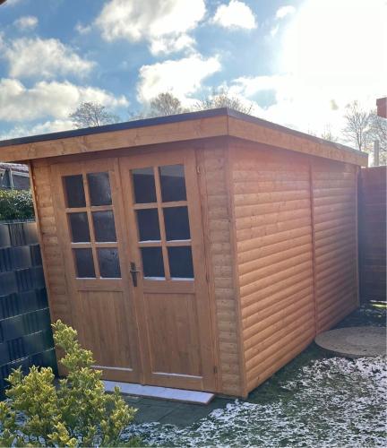 a large wooden shed with a large door at Apartment tom Brook in Bedekaspel