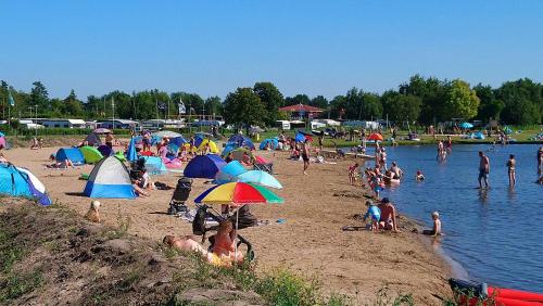 a group of people on a beach with umbrellas at Apartment tom Brook in Bedekaspel
