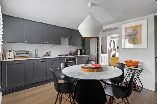 a kitchen with a table and chairs in a room at Enchanting 3BR House in Lymington with Garden in Lymington