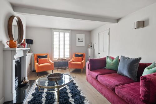 a living room with a purple couch and orange chairs at Enchanting 3BR House in Lymington with Garden in Lymington
