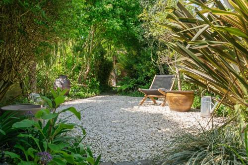 a garden with a chair sitting on a gravel path at Enchanting 3BR House in Lymington with Garden in Lymington