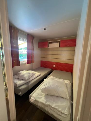 une petite chambre avec deux lits et une fenêtre dans l'établissement N004 - L'Ecrin de Verdure - climatisé - TV - proche Europa Park, à Boofzheim