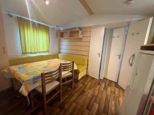 une petite chambre avec une table, des chaises et une fenêtre dans l'établissement N004 - L'Ecrin de Verdure - climatisé - TV - proche Europa Park, à Boofzheim