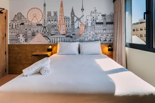 a bedroom with a large bed with a city mural on the wall at easyHotel Barcelona La Sagrera in Barcelona