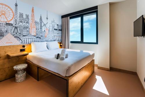 a hotel room with a large bed and a window at easyHotel Barcelona La Sagrera in Barcelona