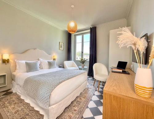 a bedroom with a bed and a desk with a laptop at Boutique Hôtel Château Beaupin Restaurant & Wellness in Marseille