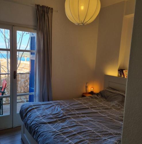 a bedroom with a bed and a large window at MARINA'S HOUSE - Serenity in Poros