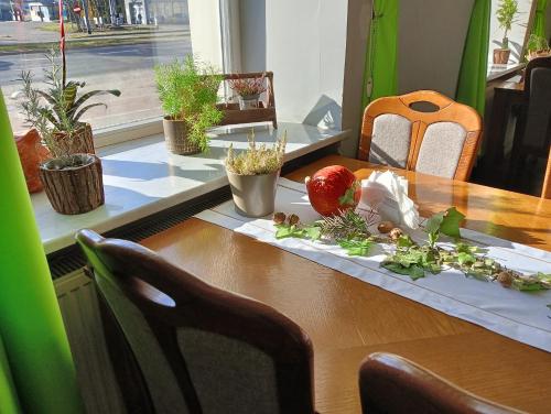 a table with a board with an apple on it at Hotel Sowa in Elblag