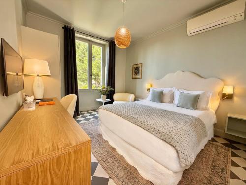 a bedroom with a large white bed and a table at Boutique Hôtel Château Beaupin Restaurant & Wellness in Marseille