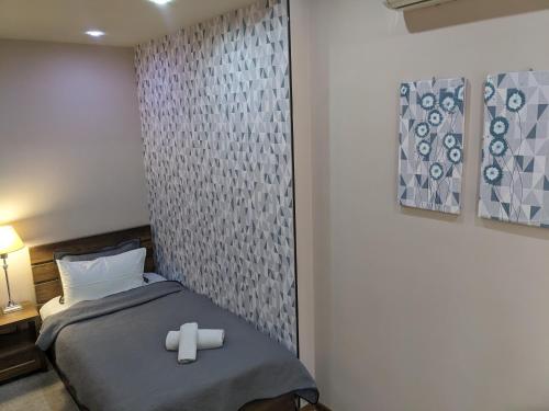 a bedroom with a bed with two rolled towels on it at Sani Hotel in Tbilisi City