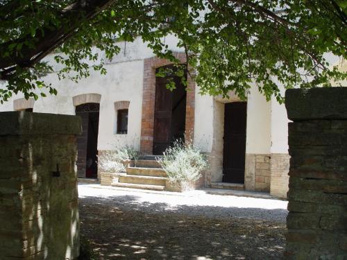 a building with doors and stairs in a courtyard at Agritourismus Vigne Di Pace The Guardian in Umbertide