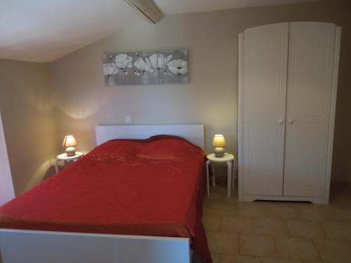 une chambre avec un lit rouge et deux tables de nuit dans l'établissement Petit gîte et Grande piscine, à Blauvac