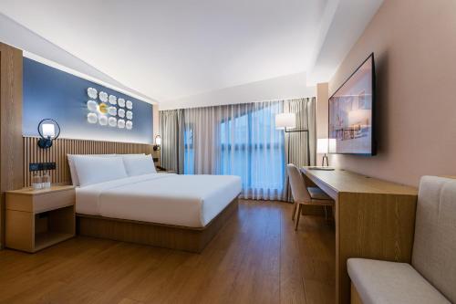 um quarto de hotel com uma cama e uma escrivaninha em 杭州西湖桔子水晶酒店 em Hangzhou