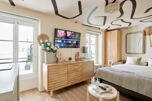 une chambre avec un lit et une télévision à écran plat dans l'établissement Lepic studio, à Paris
