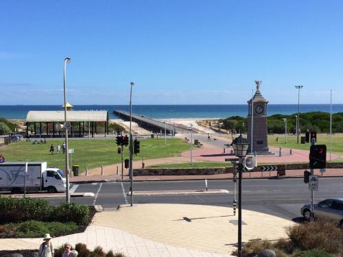 eine Straße mit einem Uhrenturm neben dem Strand in der Unterkunft Adelaide - Semaphore Beach Front in Adelaide