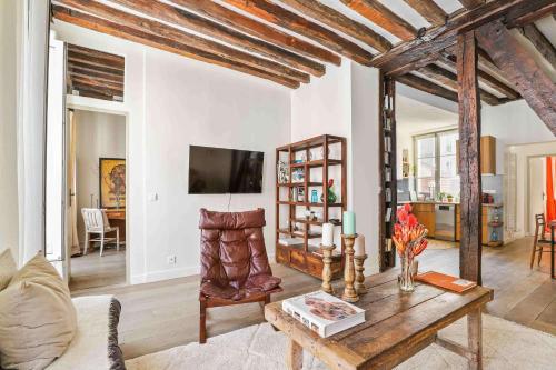 un salon avec un canapé et une table dans l'établissement Spacieux appartement au Coeur du Marais, à Paris