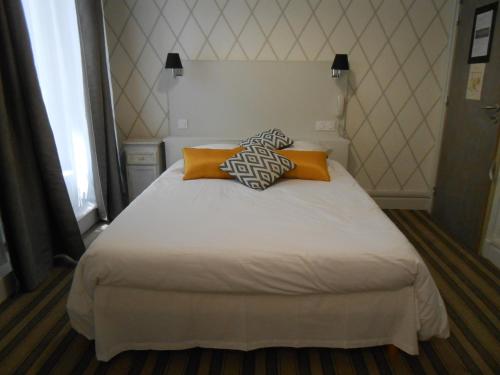 a bedroom with a bed with two pillows on it at Régina Boutique Hotel in Avignon