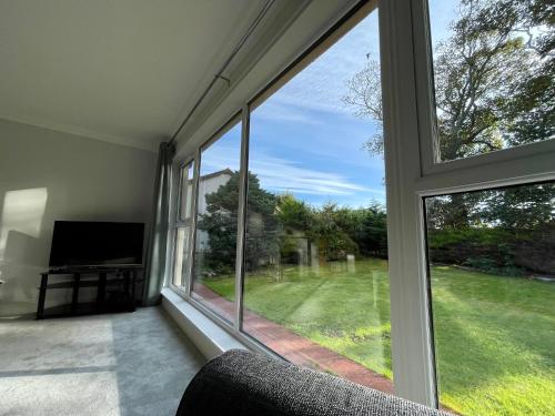 a living room with a large window and a television at Bright, Spacious 5-Bed, 4-Bathroom home on Loch Soy in Portsoy