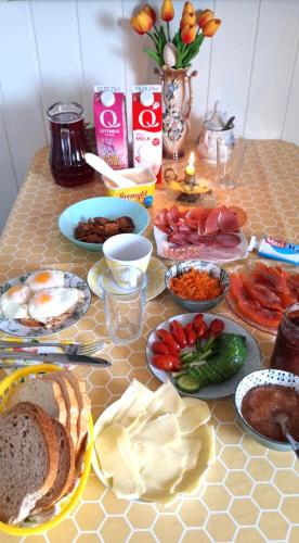 une table avec de nombreuses assiettes de nourriture dessus dans l'établissement Gjesterom til leie i et privat hus, à Brumunddalen
