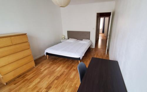 une petite chambre avec un lit et une table dans l'établissement Grand 3 pièces lumineux à 5 mn à pieds de la vieille ville, à Annecy