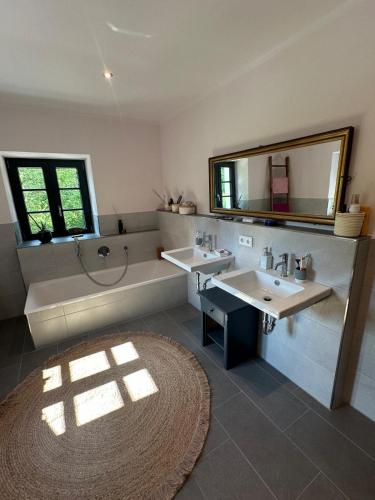 a bathroom with two sinks and a tub and a mirror at Buchmühle in Niederdorla