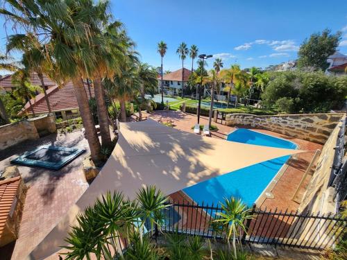 an overhead view of a swimming pool with palm trees at Near The Sea Spa Villa Resort Facilities! in Mandurah