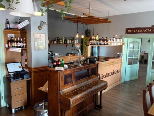 a bar with a piano in a room at Hotel Sowa in Elblag