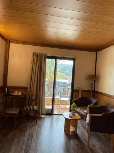 a living room with a couch and a table at Pineland Hotel and Health Resort in Ḩammānā