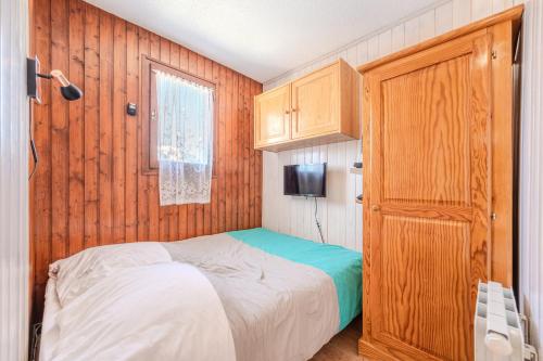 une chambre avec un lit et un mur en bois dans l'établissement Alpage AGA4 VIEW & MOUNTAIN 4 Pers, à Châtel