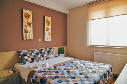 a bedroom with a bed with a checkered blanket at Hotel Bulevar in Bitola