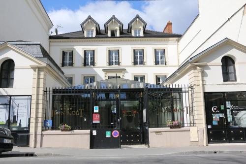 a white building with a black gate in front of it at Hotel Jean Moët in Épernay