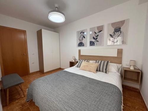 a bedroom with a large bed and some pictures on the wall at Magnifico apartamento de playa in Moncófar