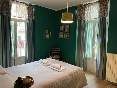 una camera da letto con un letto con pareti e finestre verdi di Green House Apartment - Como a Como