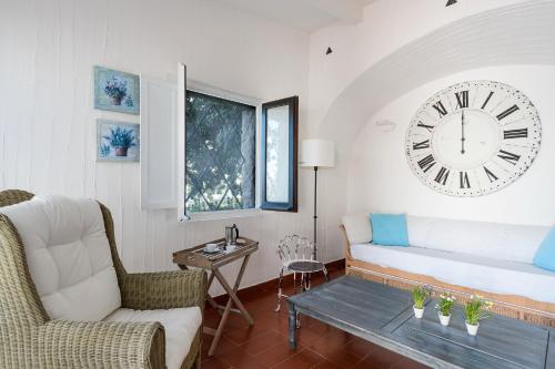a living room with a couch and a clock on the wall at Casa 15 in Castiadas