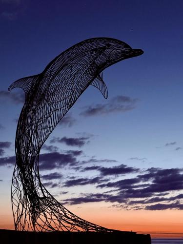 a sculpture of a whale in the sunset at Bright, Spacious 5-Bed, 4-Bathroom home on Loch Soy in Portsoy