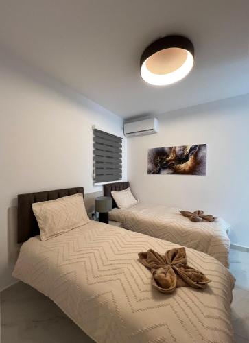a bedroom with two beds and a light fixture at Marina Bay in Marsaskala