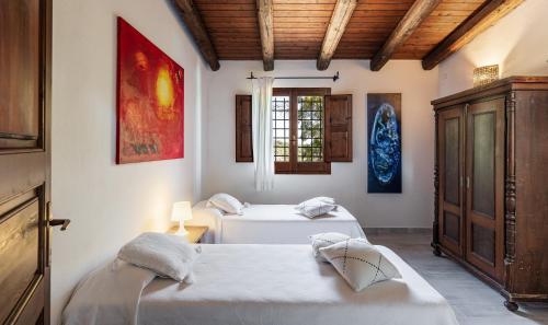 a bedroom with two beds and a window at Villa Fiori 3 in Is Molas 