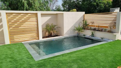 une piscine dans une cour arrière avec une clôture et de l'herbe dans l'établissement Les Terrasses de l'Etoile, à Marseille